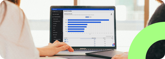 A person using a computer. The Social Media dashboard of the Siteimprove platform is showing on the screen.